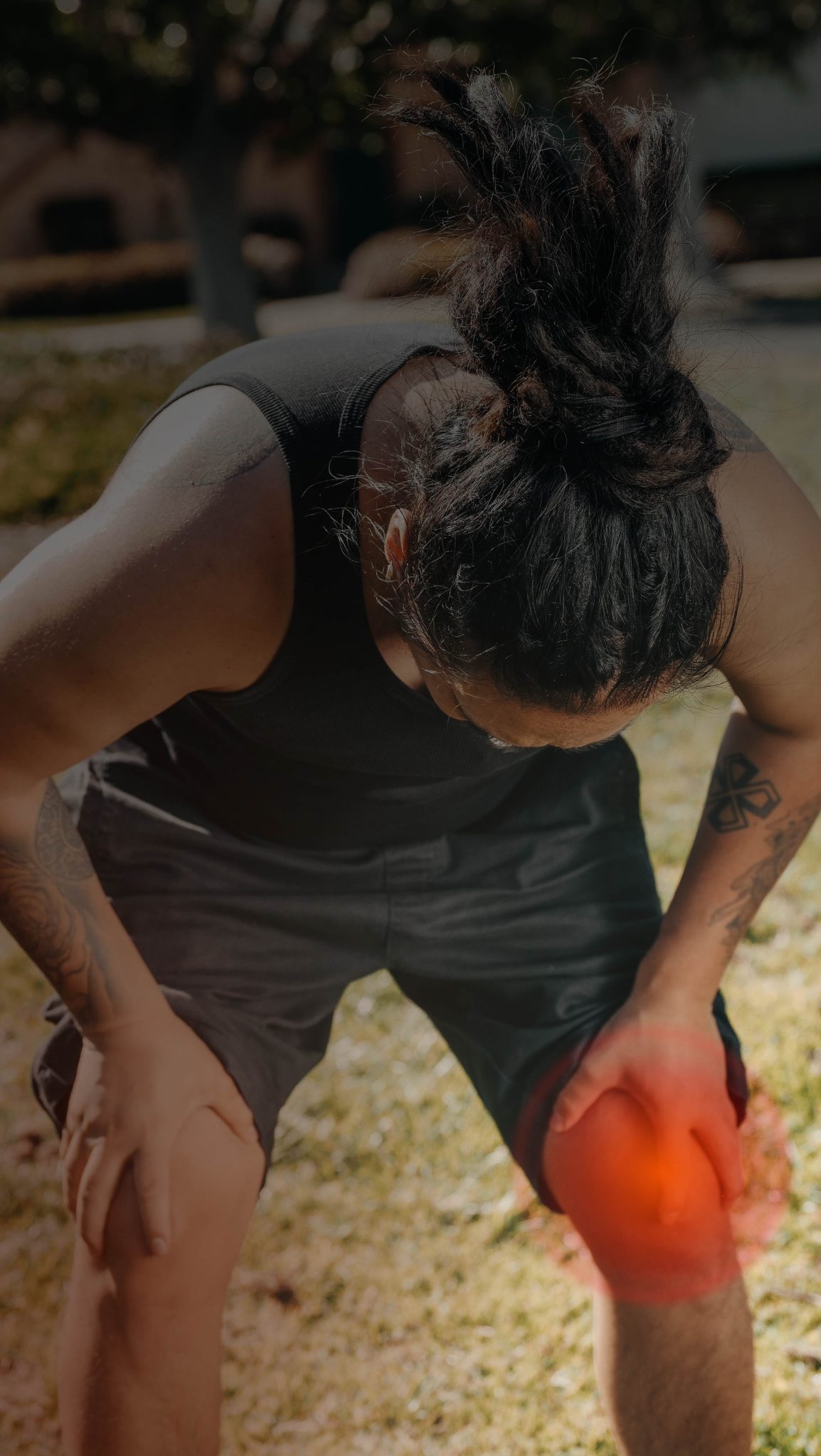 Image depicting a frustrated man holding his hurt knee due to joint pain, seeking relief through specialized training techniques for knee pain prevention. The hurt knee is highlited.